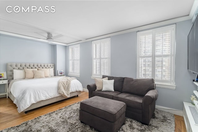 bedroom with multiple windows, crown molding, and hardwood / wood-style floors