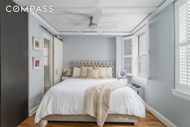 155 E 49th St Unit 10E, New York City, NY 10017 - bedroom featuring baseboards, wood finished floors, a wall unit AC, ceiling fan, and a barn door