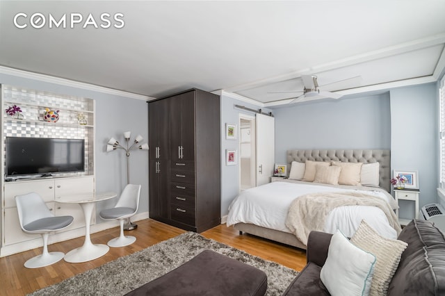 155 E 49th St Unit 10E, New York City, NY 10017 - bedroom featuring wood finished floors, ornamental molding, a barn door, and baseboards