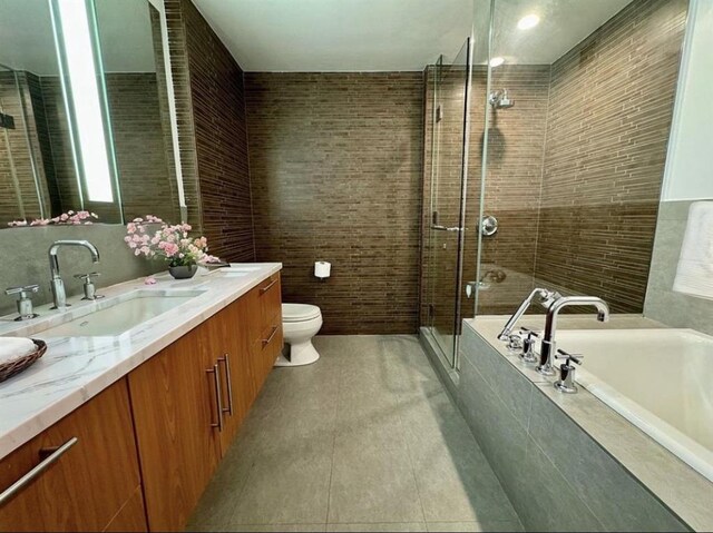 full bathroom with toilet, vanity, tile patterned floors, and independent shower and bath