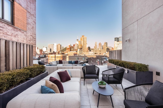 view of patio / terrace with an outdoor living space, a balcony, and a city view