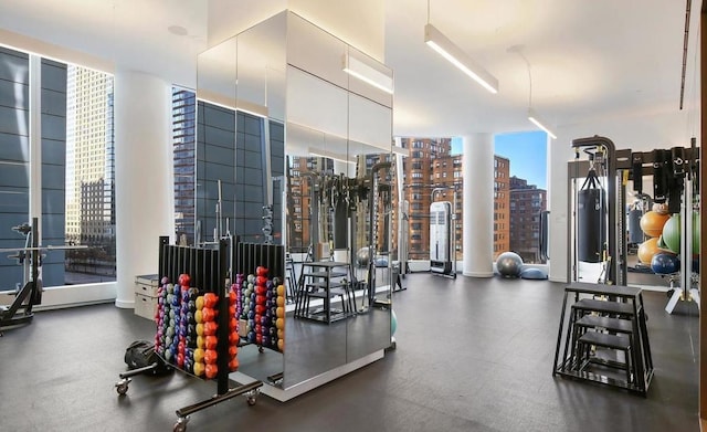 workout area with a view of city and expansive windows