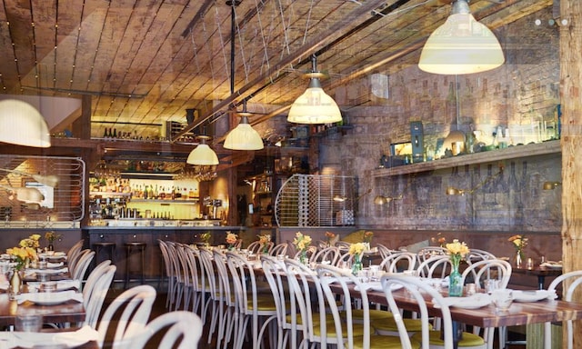 bar featuring brick ceiling and a community bar