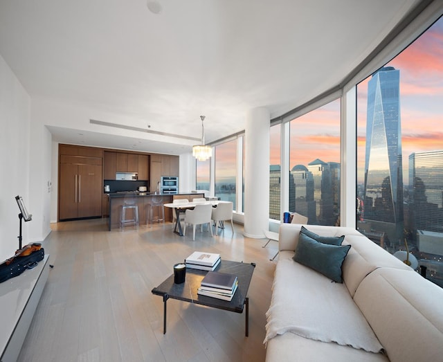 living area featuring light wood-style flooring and a chandelier