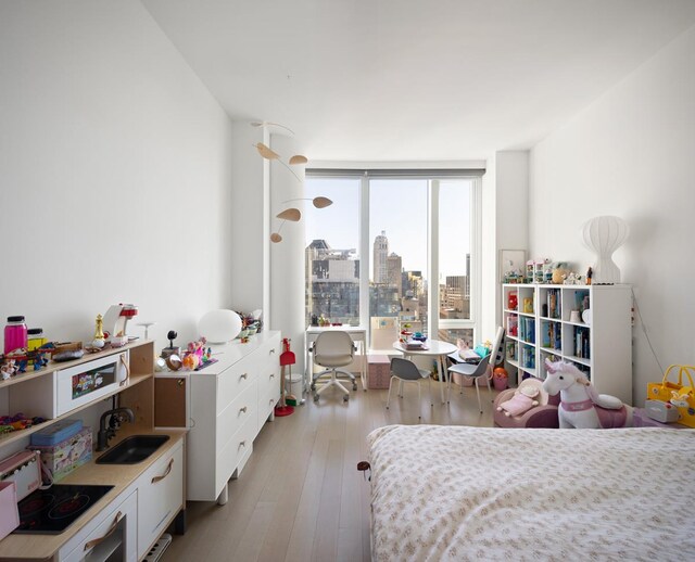 bedroom featuring light wood-style flooring and a sink