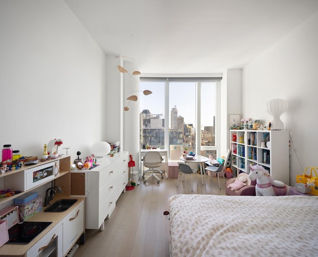 bedroom featuring light wood-type flooring and a sink