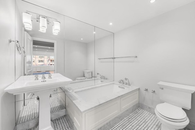 bathroom featuring a bathtub, tile patterned floors, and toilet