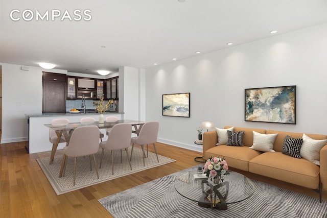 living room featuring recessed lighting, light wood-style flooring, and baseboards