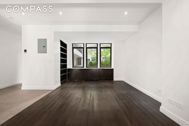 unfurnished room with dark wood-style floors, electric panel, baseboards, and recessed lighting