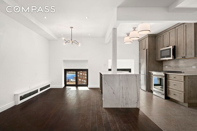 kitchen with decorative backsplash, open floor plan, dark wood-style flooring, stainless steel appliances, and a fireplace