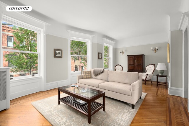 kitchen with a sink, white cabinets, light countertops, appliances with stainless steel finishes, and radiator