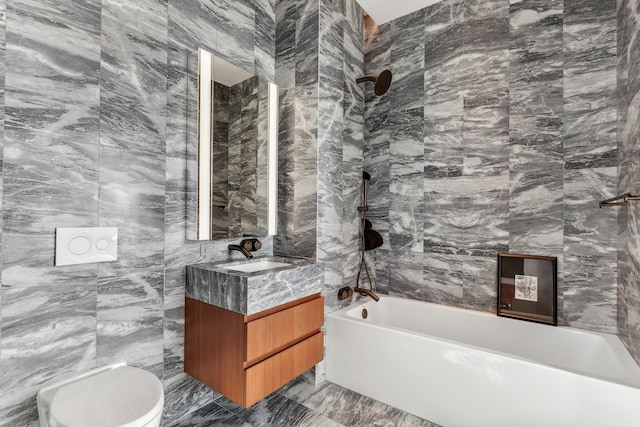 full bathroom featuring toilet, vanity, bathtub / shower combination, marble finish floor, and tile walls