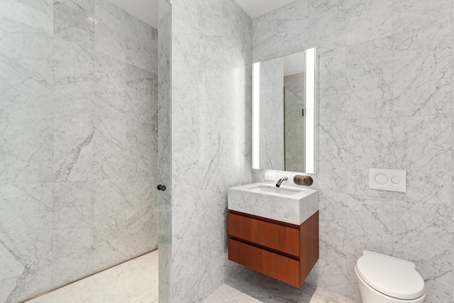 full bathroom featuring vanity, tile walls, toilet, and walk in shower