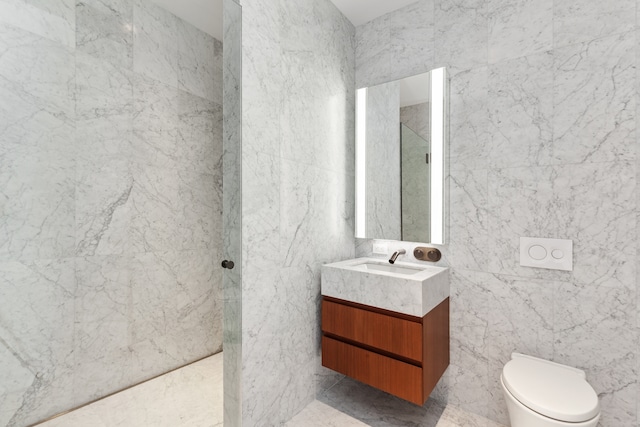 full bath featuring a walk in shower, vanity, and tile walls