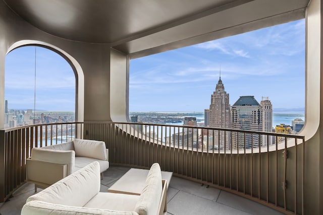 balcony featuring a water view, an outdoor living space, and a city view