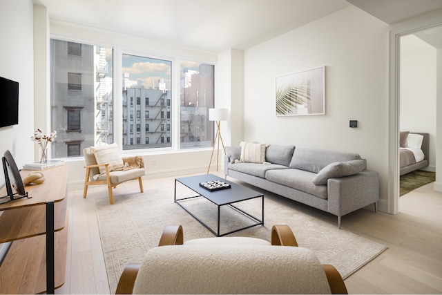 living area featuring baseboards, a city view, and light wood-style flooring