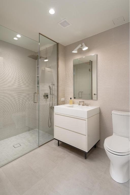 bathroom with toilet, walk in shower, and vanity