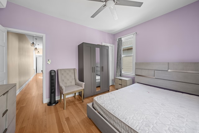 bedroom featuring light wood-style floors, ceiling fan, and baseboards