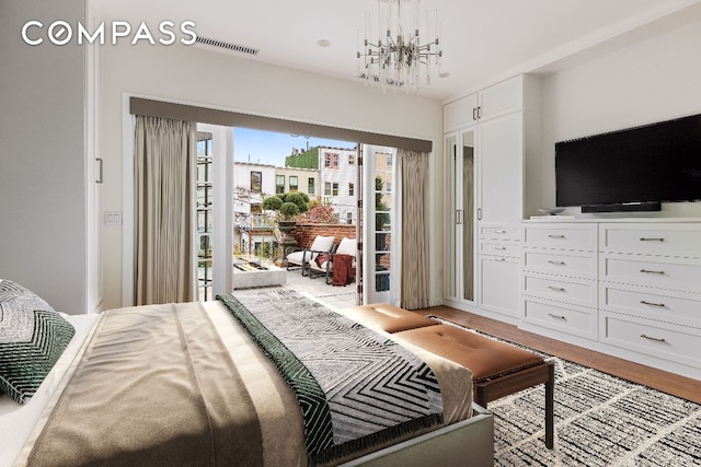 bedroom featuring access to exterior and an inviting chandelier