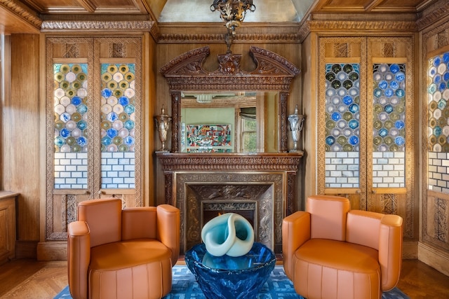 living area with parquet floors, a fireplace, ornamental molding, and wood walls