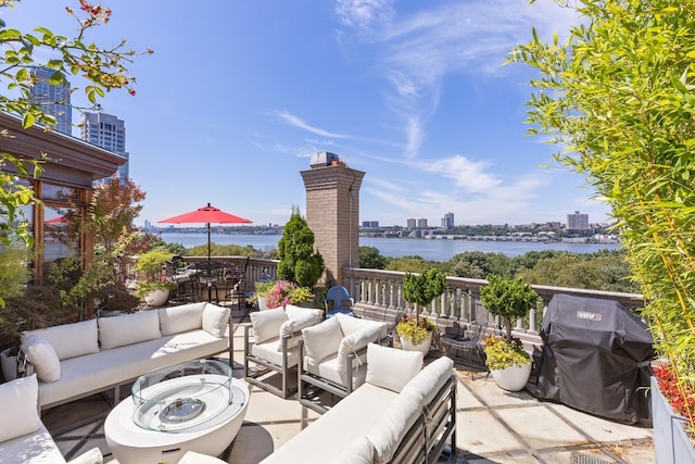 view of patio with a grill, outdoor lounge area, and a water view