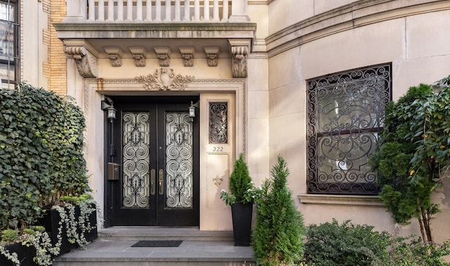 property entrance featuring a balcony and french doors