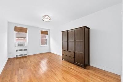 unfurnished bedroom with radiator and light hardwood / wood-style floors