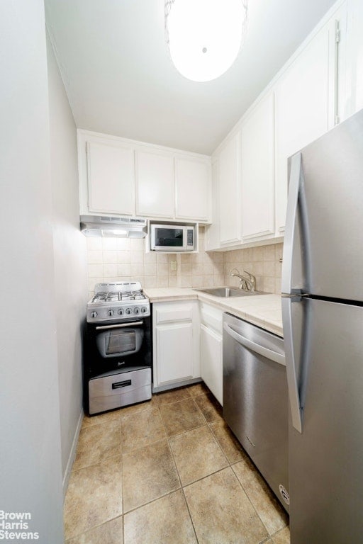 kitchen featuring white cabinetry, backsplash, and appliances with stainless steel finishes