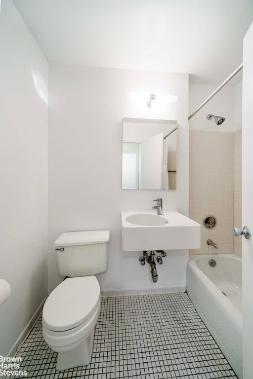 bathroom featuring tile patterned floors, toilet, and tiled shower / bath combo