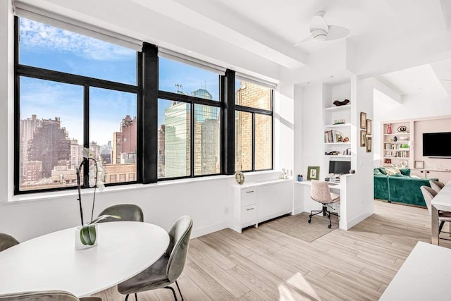 dining room with ceiling fan, light hardwood / wood-style floors, and built in features