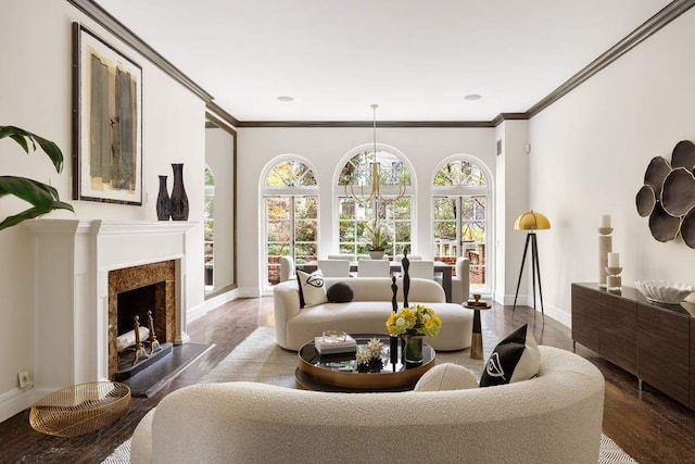 living room with a high end fireplace, crown molding, and baseboards