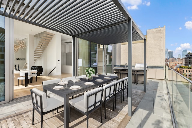 view of patio / terrace with a city view, a sink, an outdoor bar, a pergola, and outdoor dining space