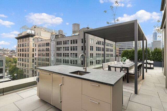 view of patio featuring outdoor dining area, exterior bar, area for grilling, a sink, and a view of city