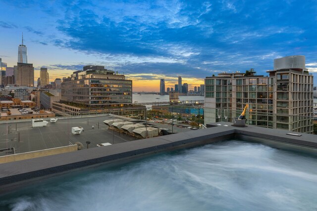 pool at dusk featuring a city view