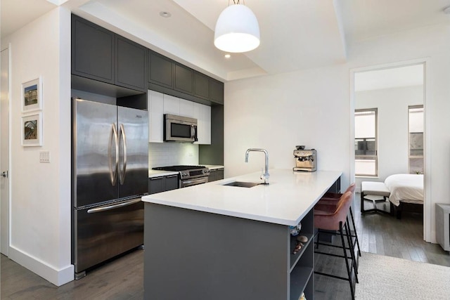 kitchen featuring decorative light fixtures, sink, dark hardwood / wood-style flooring, decorative backsplash, and stainless steel appliances