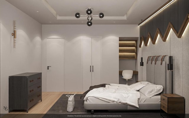 bedroom featuring a tray ceiling and light hardwood / wood-style floors