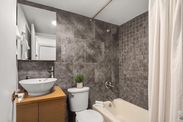 full bathroom with toilet, vanity, tile walls, and shower / tub combo with curtain