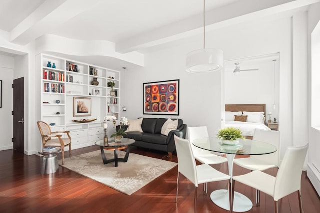 living room with ceiling fan, dark wood-type flooring, built in features, and beam ceiling