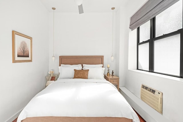 bedroom with a wall mounted air conditioner, ceiling fan, and multiple windows