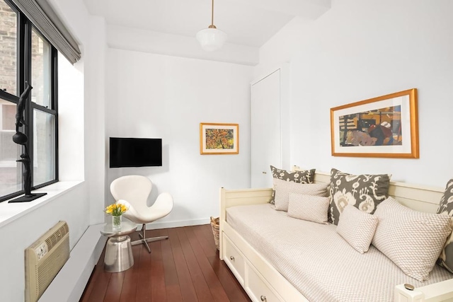 bedroom featuring dark hardwood / wood-style flooring and a wall mounted air conditioner