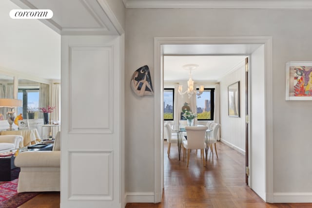 corridor with ornamental molding, visible vents, a notable chandelier, and baseboards