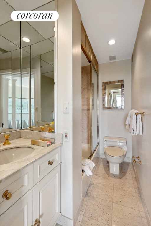 full bath featuring toilet, vanity, visible vents, baseboards, and combined bath / shower with glass door