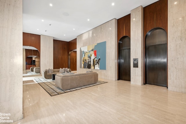 living area featuring recessed lighting, arched walkways, and elevator