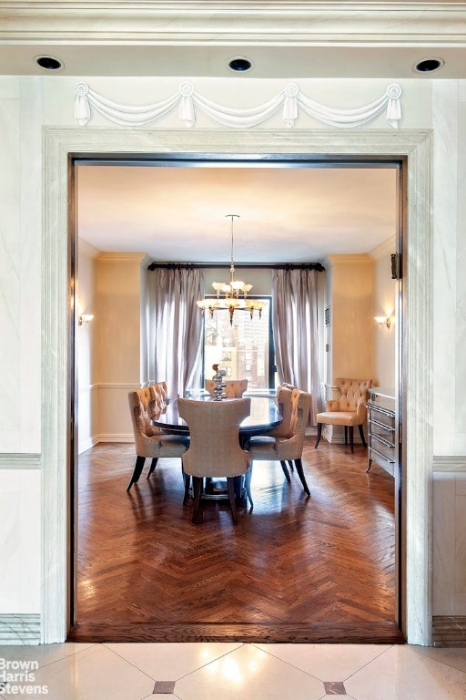 dining room featuring ornamental molding, parquet floors, and a chandelier