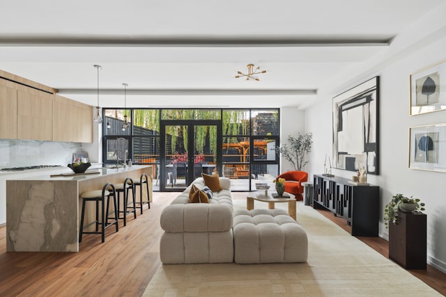 living area with wood finished floors and beam ceiling