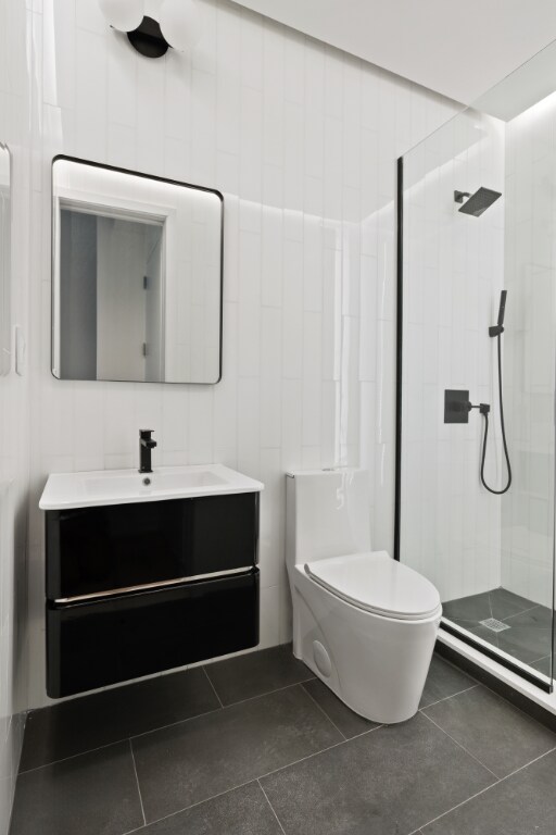 full bathroom with toilet, tile patterned flooring, a shower stall, and vanity