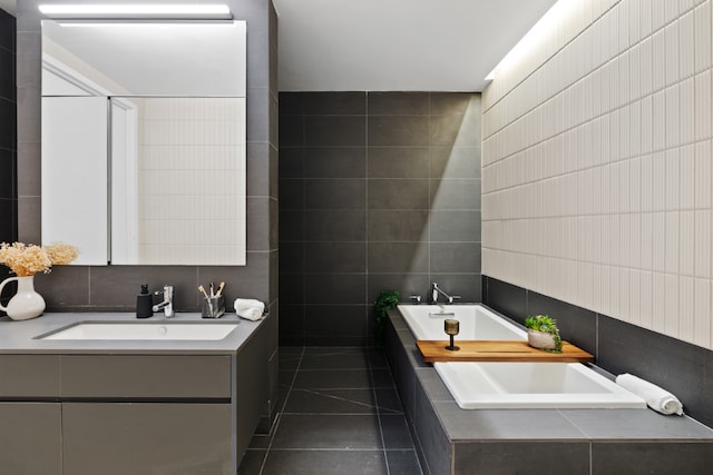 bathroom with vanity, tile patterned flooring, a garden tub, and tile walls