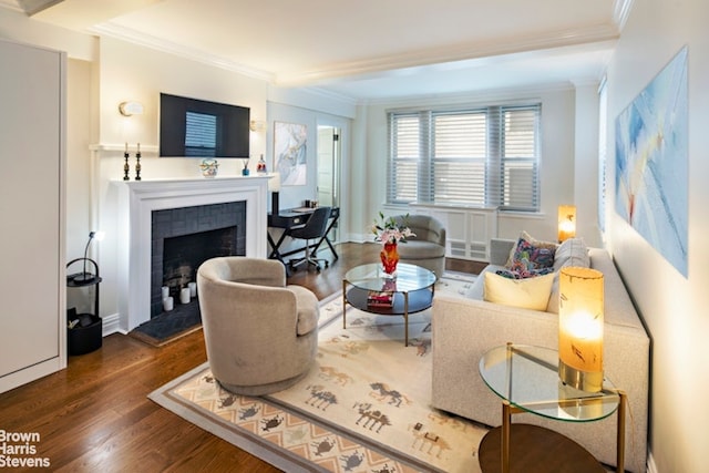 living room featuring crown molding, baseboards, dark wood-type flooring, and a tile fireplace