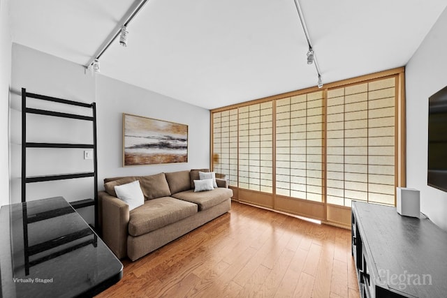 living room with rail lighting and light hardwood / wood-style floors