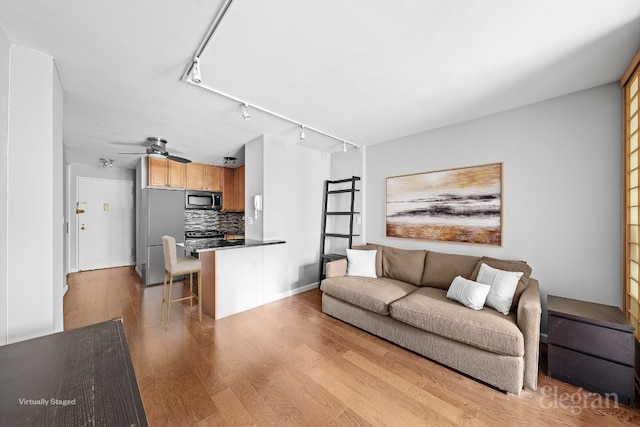 living room featuring ceiling fan and light hardwood / wood-style flooring